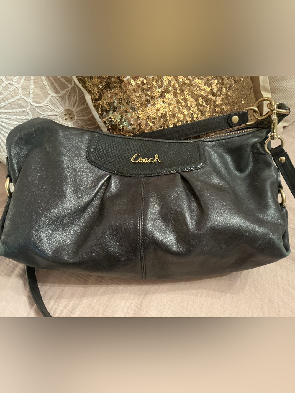 Elegant Coach shoulder bag in black pebbled leather. Gold-tone hardware accents.